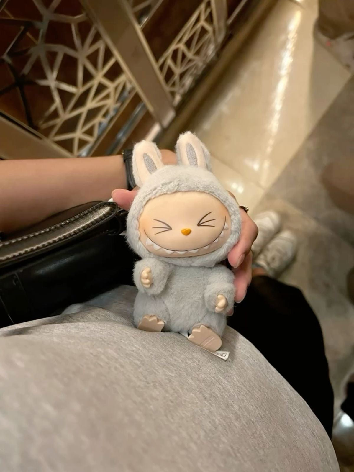 Plush toy resembling a character in a bunny costume held by a person.
